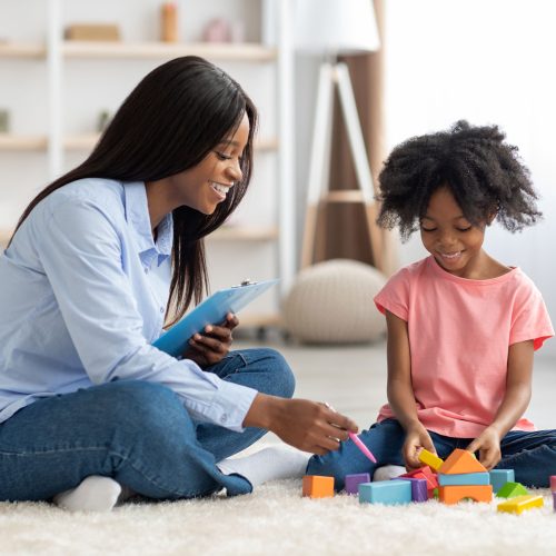 adorable-black-kid-and-child-psychotherapist-playing-with-bricks